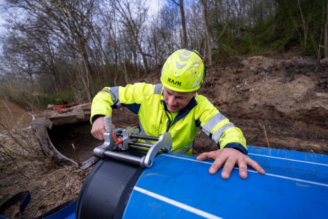 En driftsmedarbejder monterer et vandrør