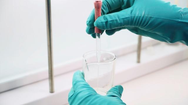 En laborant arbejder med en prøve i et reagensgals